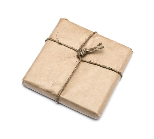 Paquete envuelto con papel kraft marrón aislado sobre fondo blanco — Foto de Stock