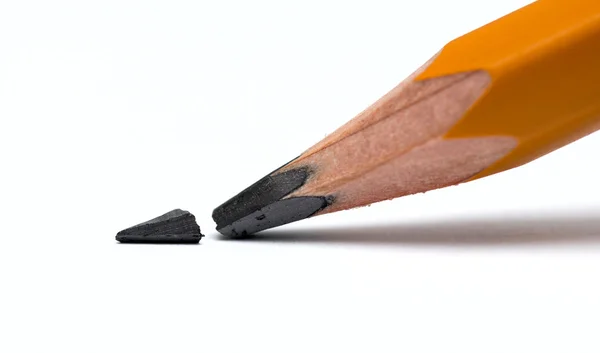 Broken head of sharp pencil on a white paper — Stock Photo, Image