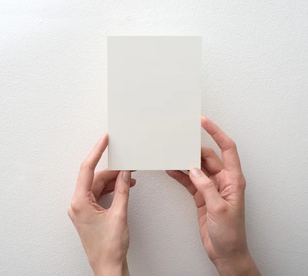 Mão segurando cartão em branco no fundo branco — Fotografia de Stock