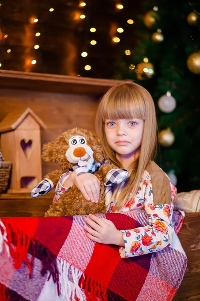 Menina segurando brinquedo perto da árvore de natal — Fotografia de Stock