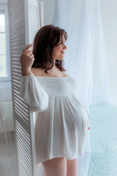 Красива м'яка і чуттєва вагітна дівчина в білому — стокове фото