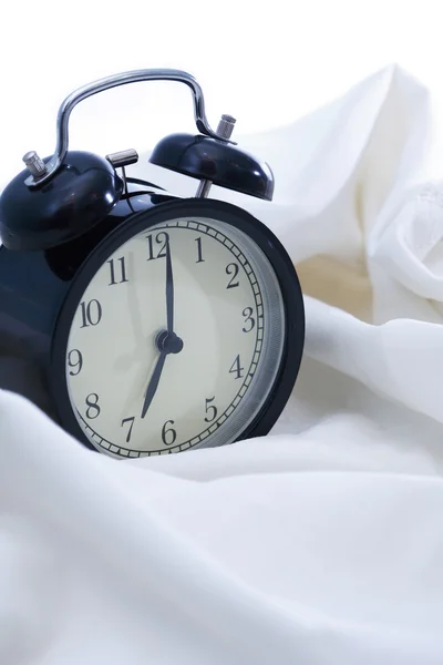 Reloj despertador en la cama — Foto de Stock