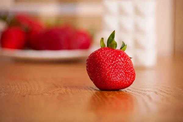 Fresa madura sobre una superficie de madera. fondo de fruta — Foto de Stock