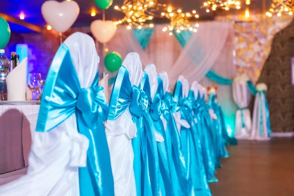 Stoelen met feestelijke blauwe bogen — Stockfoto