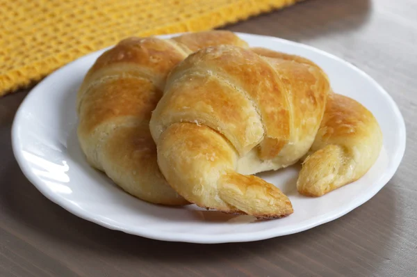 Čerstvé croissanty na desku — Stock fotografie