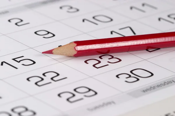 Lápis vermelho sobre o calendário — Fotografia de Stock