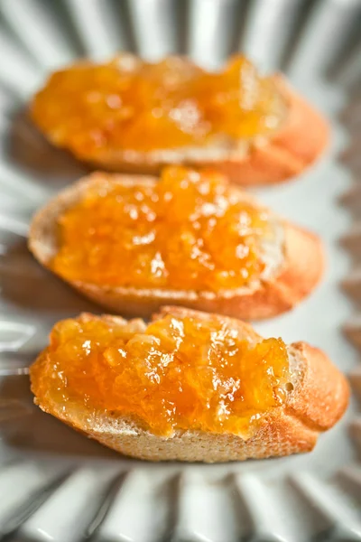 Pieces of baguette with orange marmalade — Stock Photo, Image