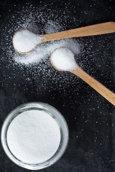 Sugar in wooden spoons and glass jar — Stock Photo, Image