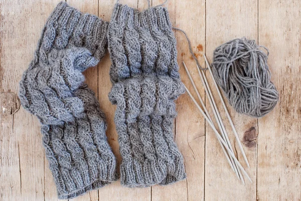 Wool grey legwarmers, knitting needles and yarn — Stockfoto
