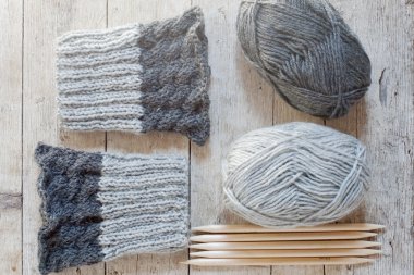 wool grey legwarmers, knitting needles and yarn