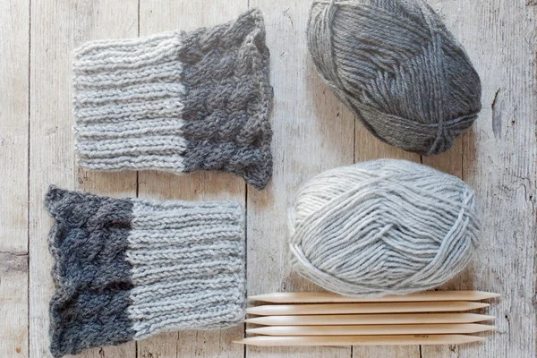 Wool grey legwarmers, knitting needles and yarn — Stockfoto