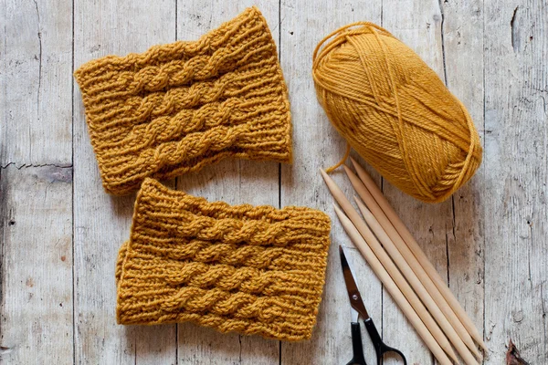 Wool yellow legwarmers, scissors, knitting needles and yarn — стоковое фото