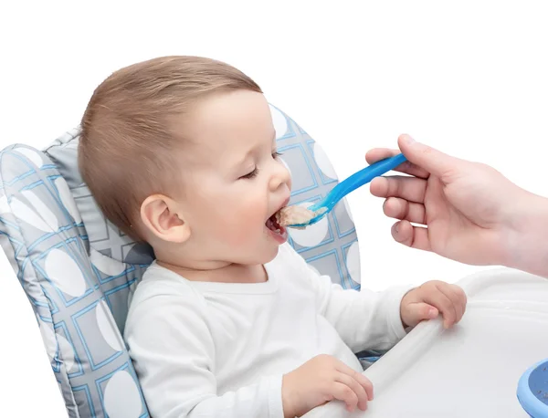 The one-year-old kid is fed with porridge Royalty Free Stock Images