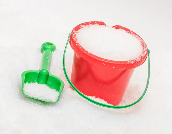 Le seau rouge vert et la pelle qui sont remplis de neige — Photo