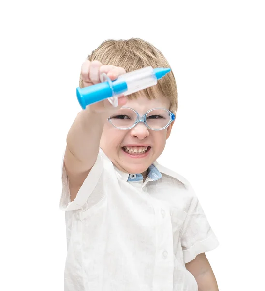 The five-year-old boy wearing spectacles is angry, in hands the toy syringe — Stock Photo, Image