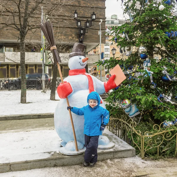 Menino de cinco anos, na rua decorado pelo Natal — Fotografia de Stock
