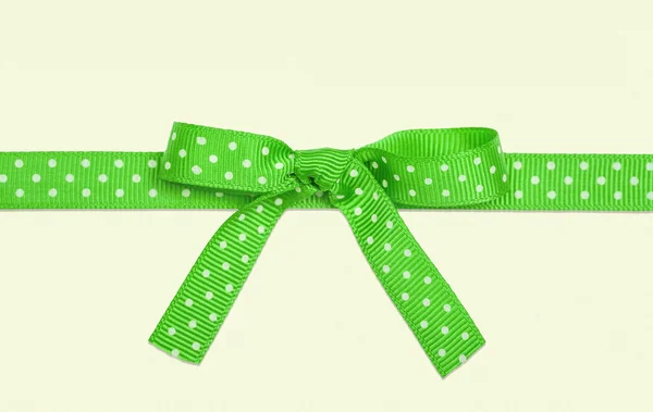 Подарок в упаковке с зеленым луком белый в горох — стоковое фото