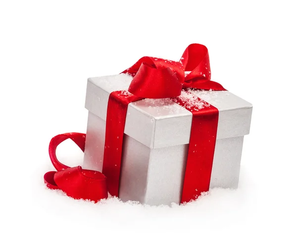 Gift box with a red bow on snow isolated on the white — Stock Photo, Image