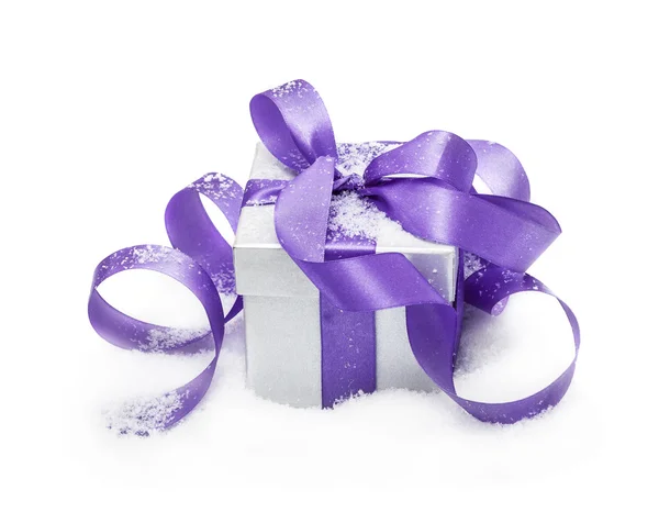 Coffret cadeau avec un noeud lilas sur neige isolé sur le blanc — Photo