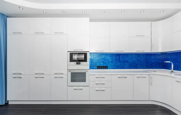 Ruime moderne witte blauwe interieur keuken / eetkamer met ingebouwde huishoudelijke apparaten — Stockfoto