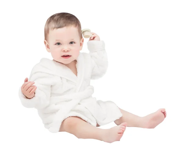 Il bambino di un anno in vestaglia bianca con una spazzola per capelli in una mano — Foto Stock