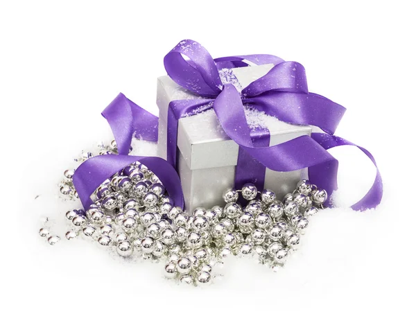 Coffret cadeau avec un noeud lilas sur neige isolé sur le blanc — Photo