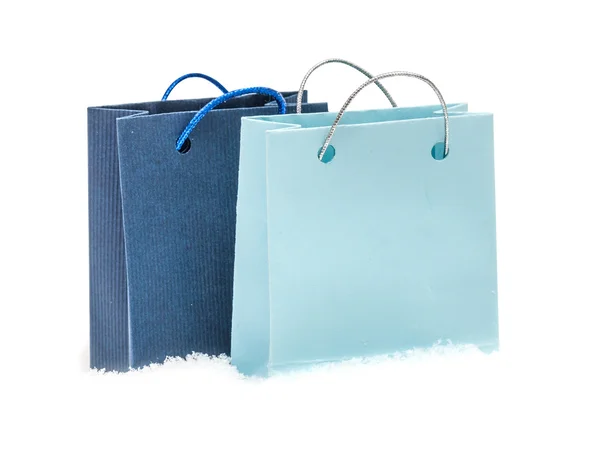 O pacote de presente azul custa na neve, isolado no branco — Fotografia de Stock