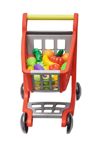 El carro de plástico infantil con verduras y frutas de plástico, aislado en el blanco — Foto de Stock