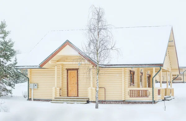 Birke und Holzhaus bei Schneefall im Moskauer Gebiet — Stockfoto