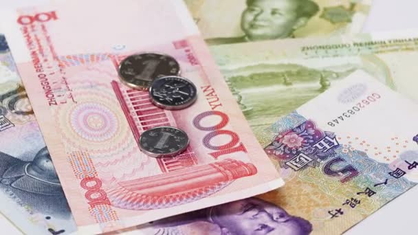 Banconote e monete in Yuan che ruotano sullo sfondo delle attività — Video Stock