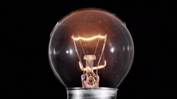 Лампа Эдисона лампа мигает над черным, макро вид, петля — стоковое видео