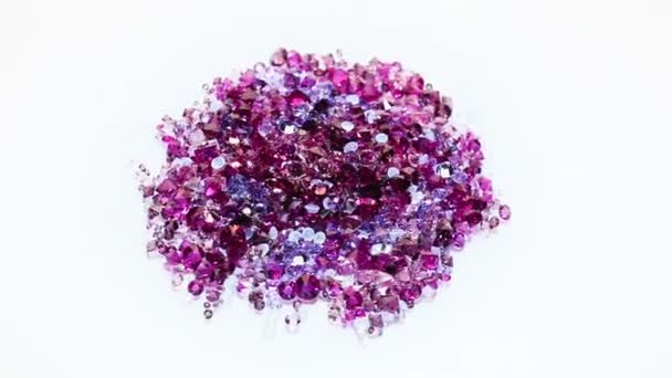 Jewel stones heap in violet tones spinning over white background — Stock Video