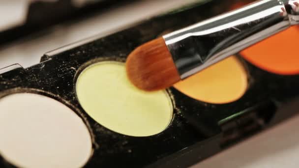 Cepillo de maquillaje moviéndose sobre la paleta de sombras multicolor — Vídeos de Stock