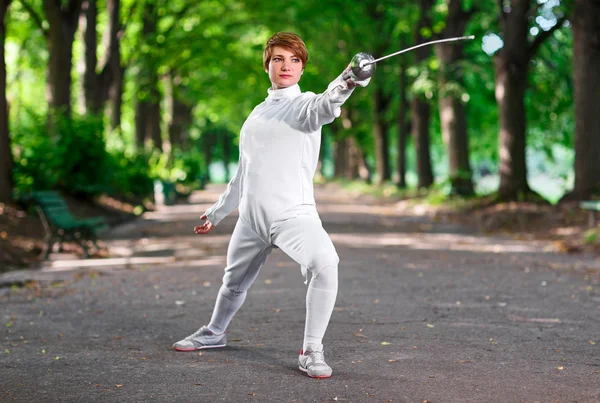 Young beautiful rapier fencer woman staying in park alley ready — Stock Photo, Image