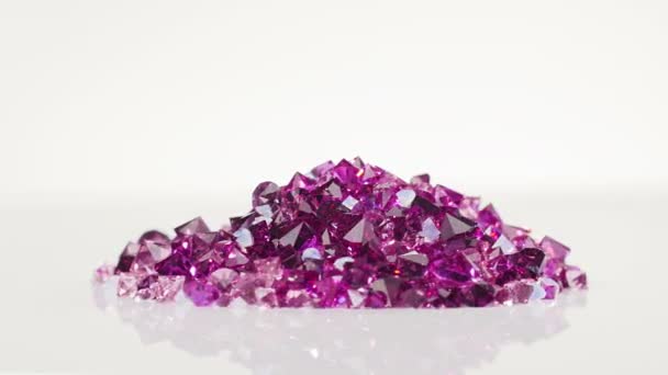 Violet juweel stenen heap draaien op witte achtergrond — Stockvideo