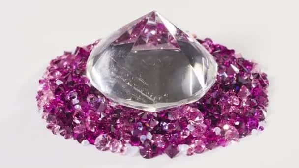 Riesiger Diamant mit vielen kleinen Edelsteinen, die über weißem rotieren, schlaufenfertig — Stockvideo