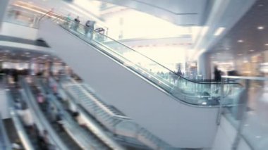 Alışveriş merkezinde yürüyen merdivenüzerinde hızlı hareket eden insanların soyut arka plan