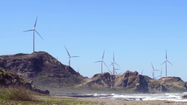 Orilla del mar con turbinas de viento girando — Vídeo de stock