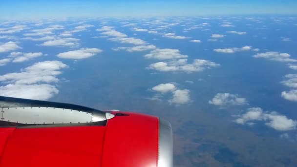 Airplane flies above the clouds. Jet turbine engine through the airliner window — Stock Video