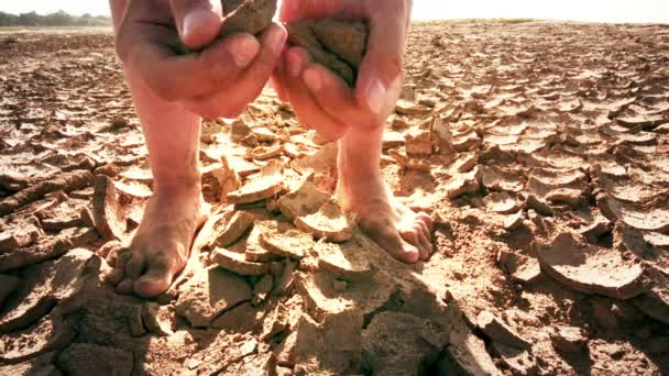 Man scheuren bodem van droge grond — Stockvideo