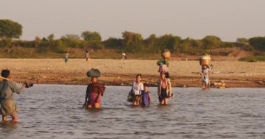 Eve dönerken sığ nehri geçen yerel köyden Birmanya vatandaşları