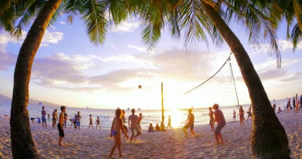 Touristen spielen Beachvolleyball bei Sonnenuntergang am Sandstrand der tropischen Insel — Stockvideo