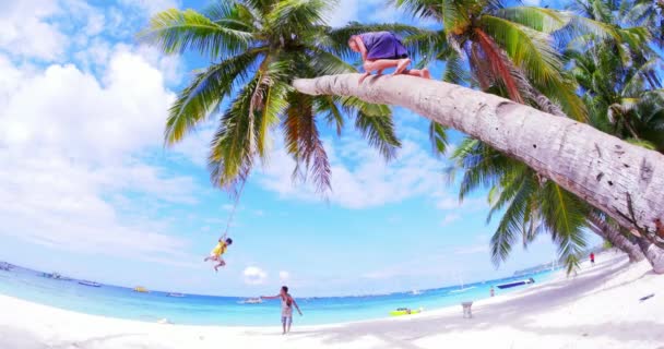 Gyermekek szórakozhatnak, és játszanak a homokos strandon a trópusi szigeten. Életmód — Stock videók