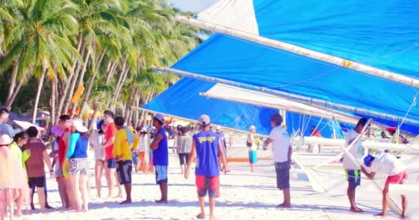 Turistas y propietarios de veleros locales en la playa de arena de la isla tropical — Vídeos de Stock