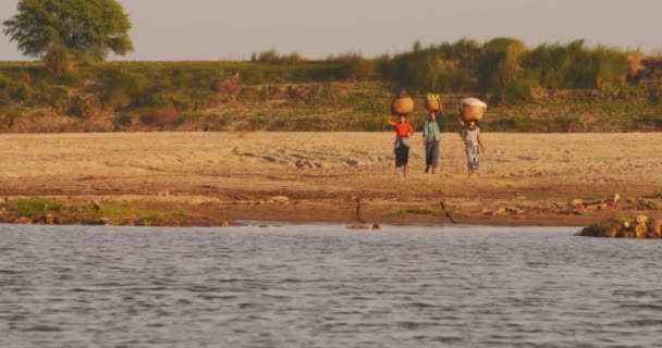 Barmští vesničané vracející se z polí a přes řeku Irrawaddy při západu slunce. — Stock video