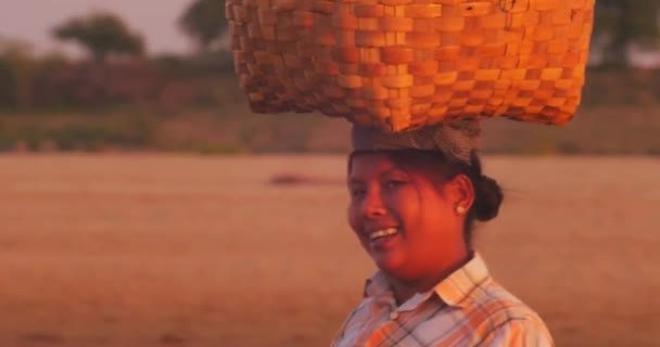 Mujer birmana lleva canasta de mimbre tradicional en la cabeza y sonríe — Vídeos de Stock