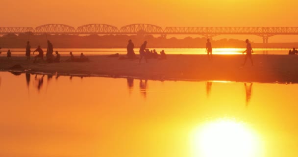 Evening sunset sky reflect in water of Irrawaddy river and young Burmese monks — Stock Video