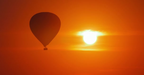 Montgolfière volant sur le ciel couchant 