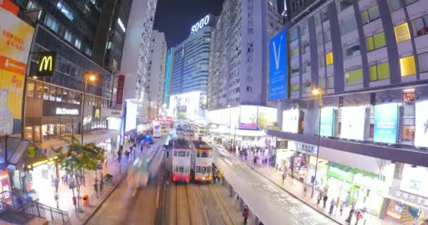 Hongkong центре города ночью со многими трамваями, автобусами и людей, движущихся в поздний час — стоковое видео