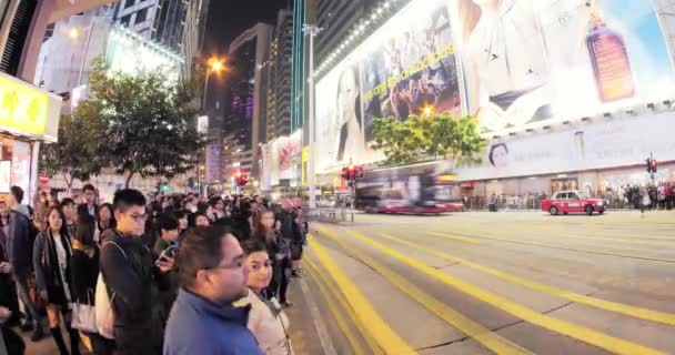 Mensen passeren drukke straat in Hongkong Downtown 's nachts. Openbaar vervoer — Stockvideo